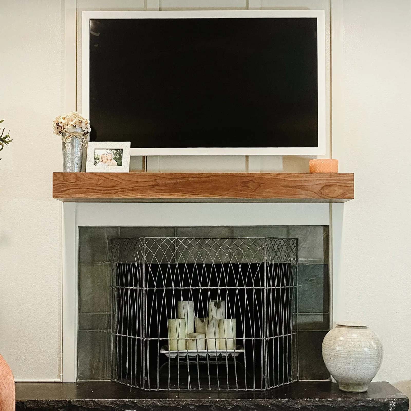 A thick wood mantel styled beneath a television above a fireplace. Photo from ultrashelf.com.