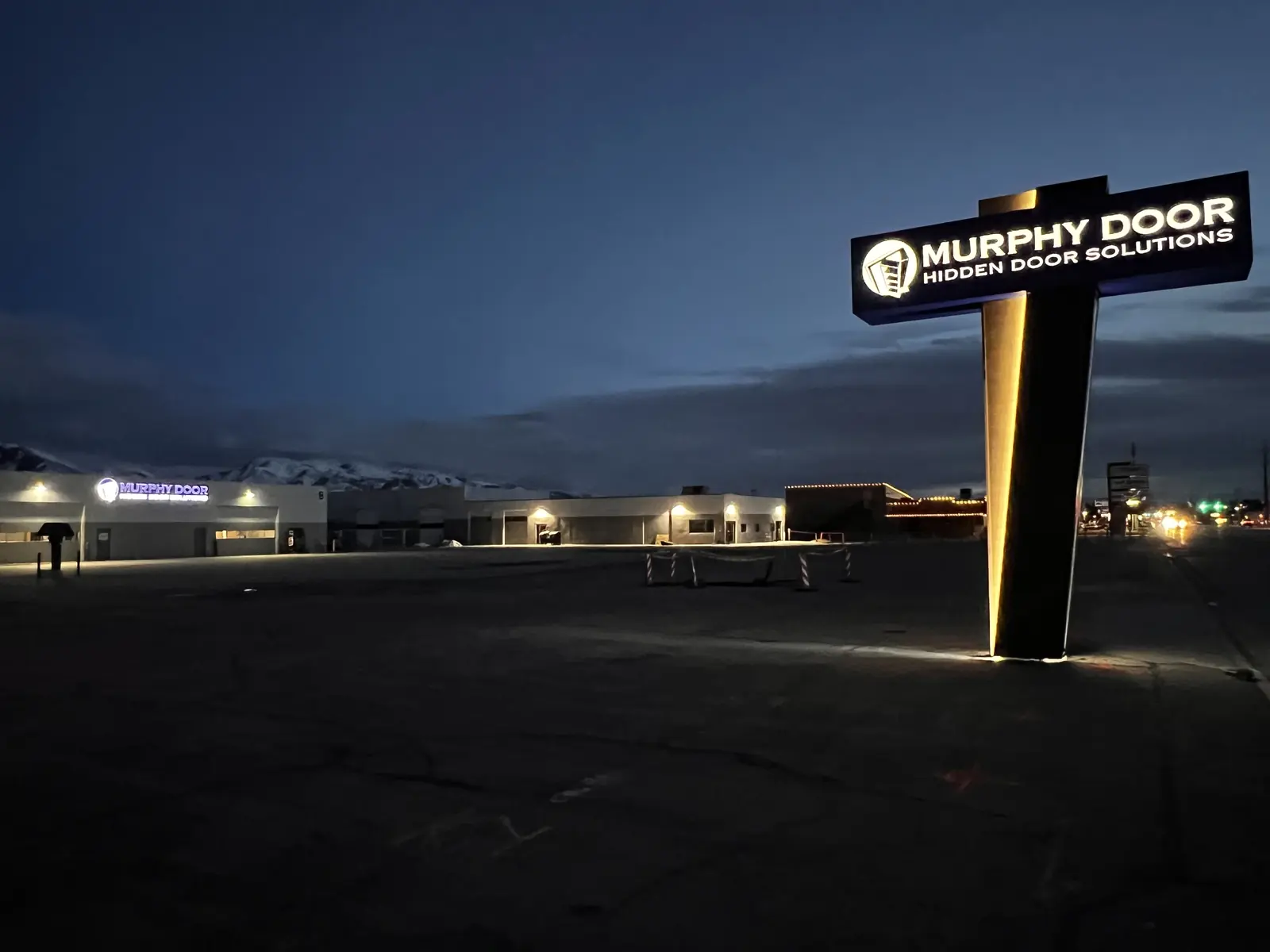The Murphy Door® monument sign lit at night, snow on the mountains behind. Company photo.