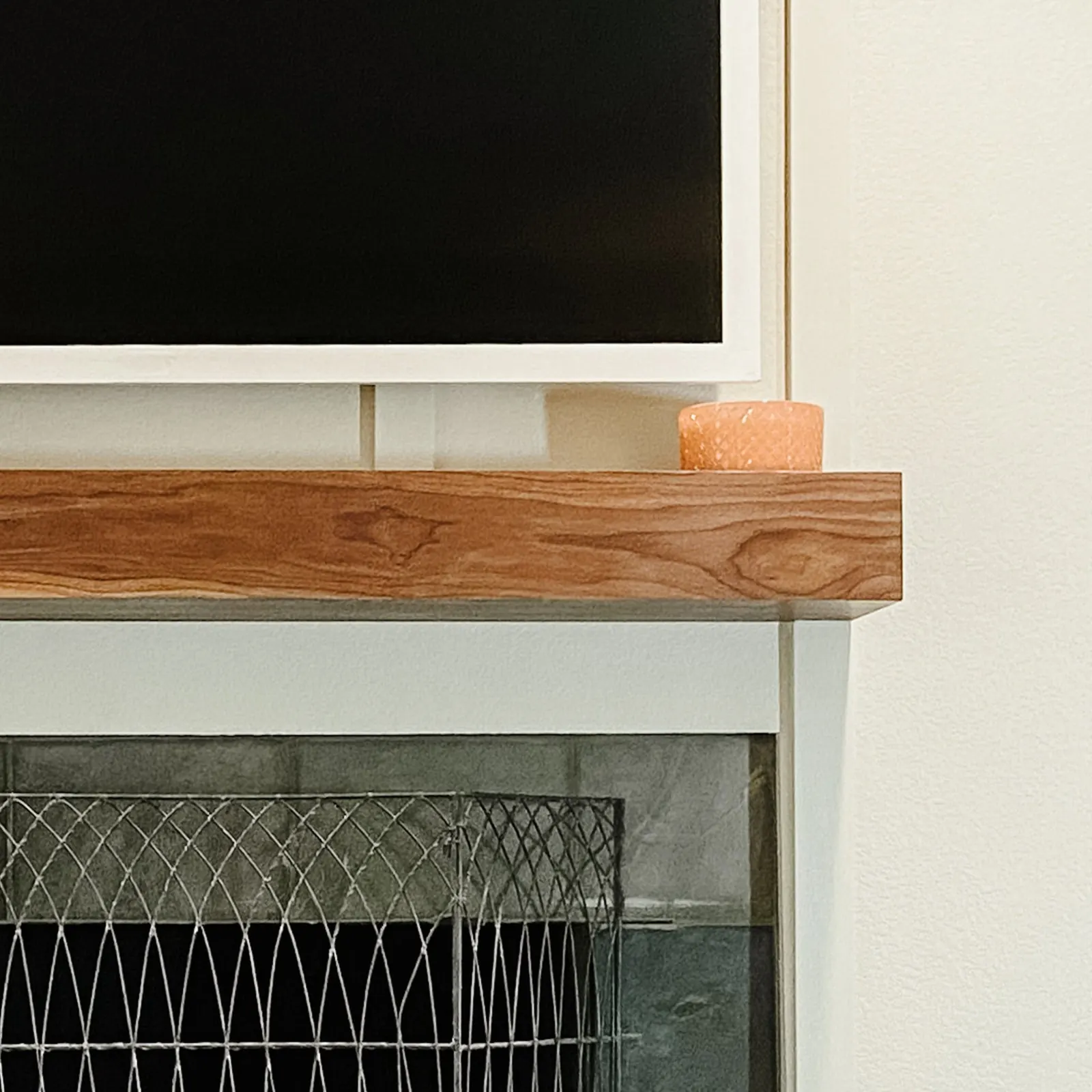 A thick walnut beam mantel over a dark slate firebox. Photo from ultrashelf.com.